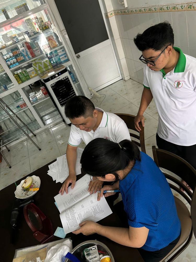Nhân viên hướng dẫn nhân viên nhà thuốc ghi sổ sách