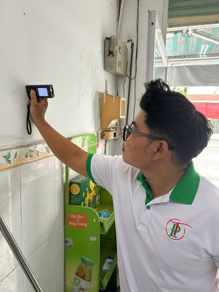 Nhân viên kiểm tra nhiệt ẩm kế treo tường