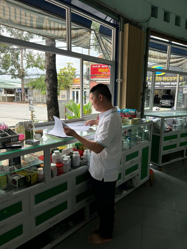 Nhân viên đứng xem hồ sơ tại quầy nhà thuốc